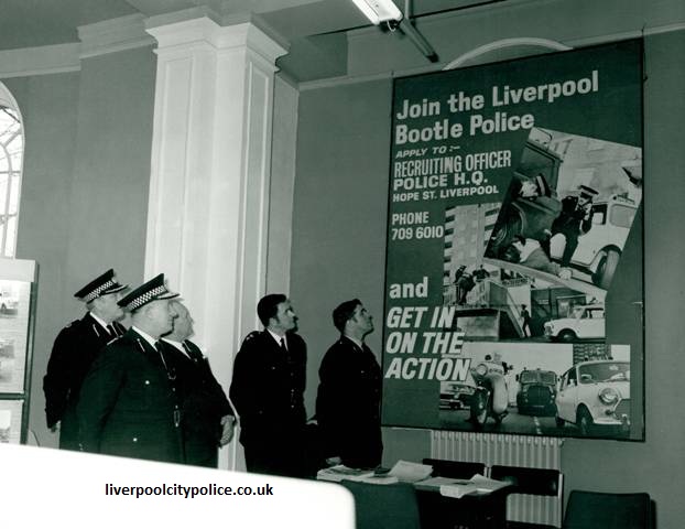 Liverpool & Bootle Constabulary officers viewing a recruitment poster containing several photographs of Police Minis and other operational police activity.