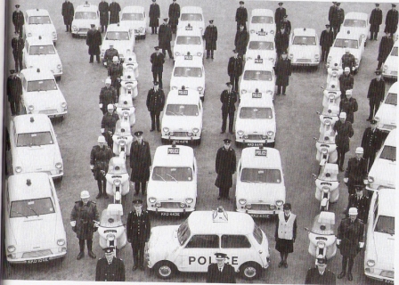 Elevated 1967 Liverpool & Bootle Constabulary fleet line-up with Austin Mini Cooper S cars, Ford Anglias, police motorcycles and uniformed officers.